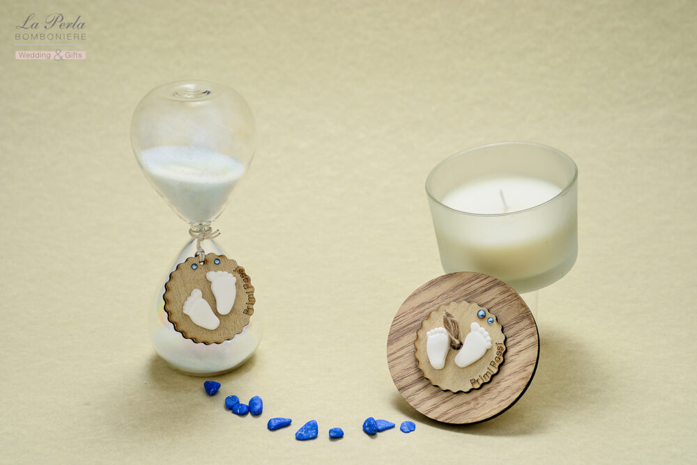Clessidra e candela profumata della collezione Primi Passi, decorate con due piccoli piedini a gessetto profumato. Possibilità di scrivere il nome del bimbo.